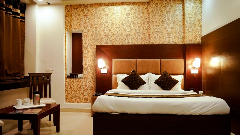 An alternate view of the Deluxe Room with queen bed and warm lighting